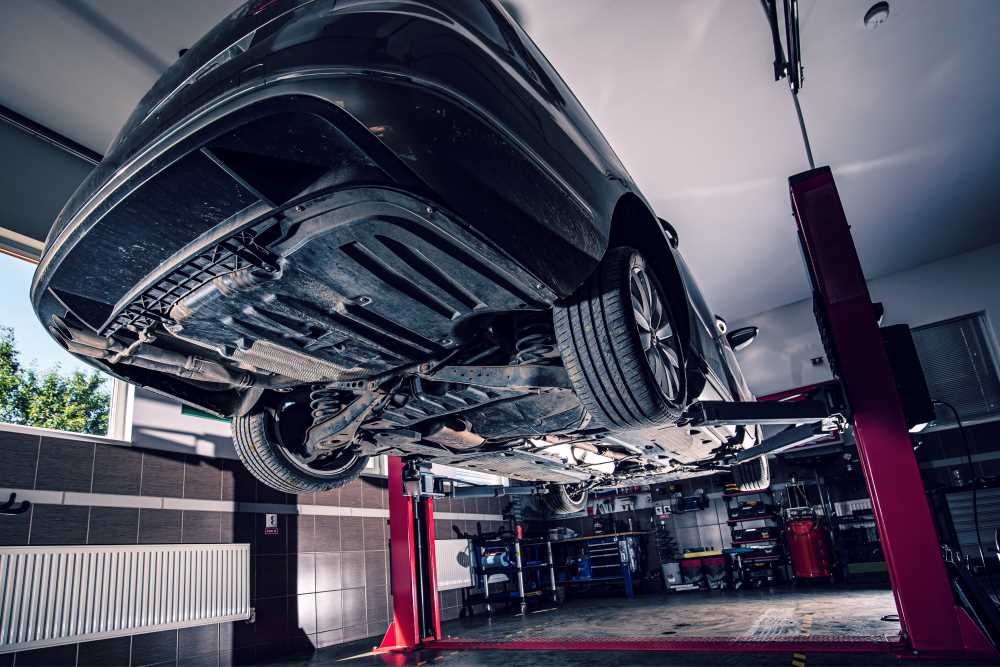 lifted-car-in-garage-2023-11-27-05-15-47-utc Поднятая машина в гараже. Концепция ремонта в мастерской. Обслуживание карданного вала